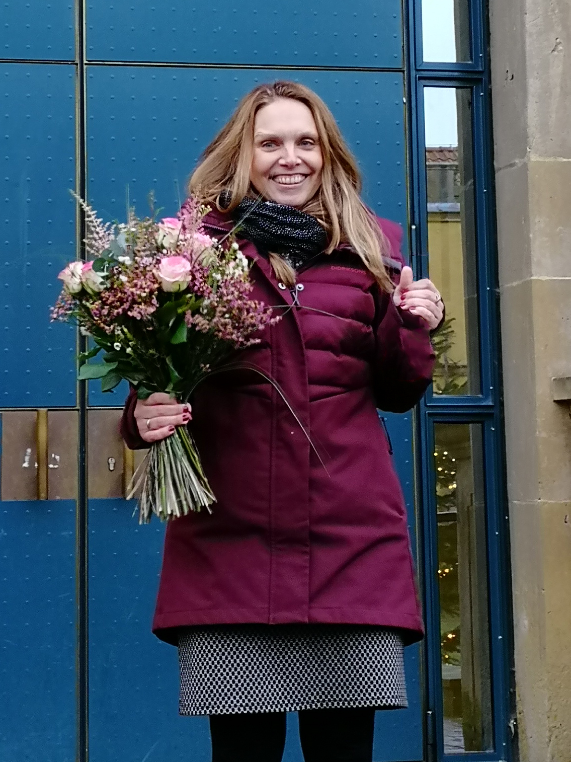Sara Marquard nach der Disputation ihrer Dissertation mit Blumen vor dem Schloss der Universität Osnabrück